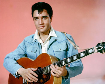 Elvis Presley in blue holding a guitar

