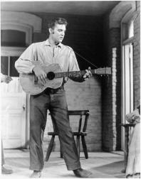 Elvis Presley playing guitar in black and white