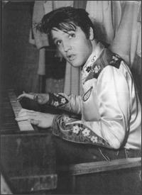 Elvis Presley playing piano in black and white picture
