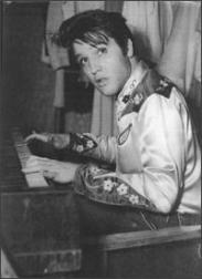 Elvis Presley playing piano in black and white picture