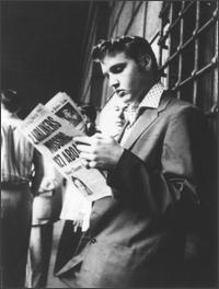 Elvis Presley reading news papers
