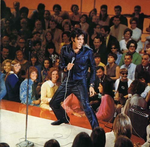 Elvis Presley singing among fans
