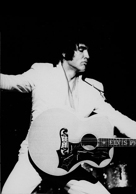 Elvis Presley singing and playing guitar
