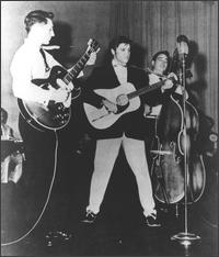 Elvis Presley singing with his band
