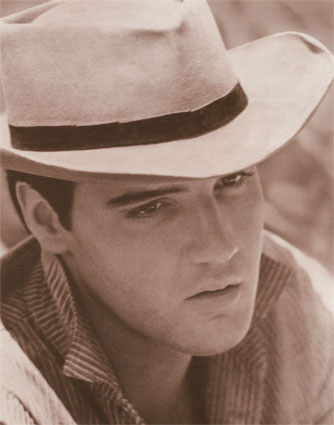 Elvis Presley wearing a hat with charm
