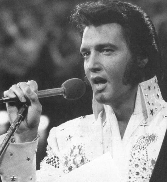 Elvis singing in white outfit
